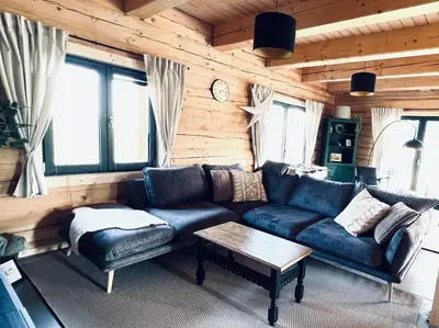a living room with a blue couch and a table at Kowalowa Chata Zawoja in Zawoja