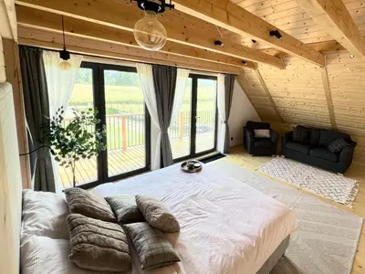 a large bed in a room with a large window at Kowalowa Chata Zawoja in Zawoja