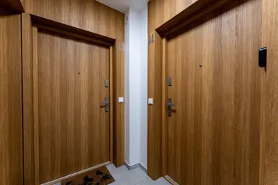 a row of wooden doors in a hallway at Gusta Cosy Apartment by BookingHost in Kraków