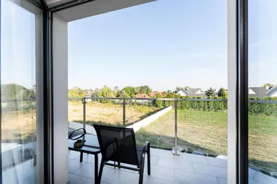 a glass door leading to a balcony with a table and chair at Gusta Cosy Apartment by BookingHost in Kraków