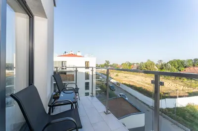 a balcony with two chairs and a view at Gusta Cosy Apartment by BookingHost in Kraków
