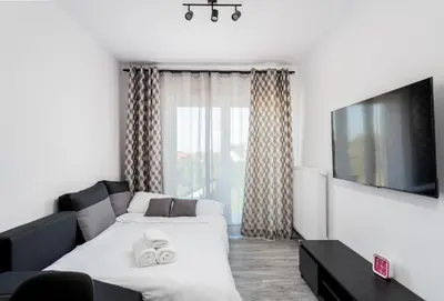 a living room with a couch and a tv at Gusta Cosy Apartment by BookingHost in Kraków