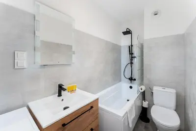 a white bathroom with a sink and a toilet at Gusta Cosy Apartment by BookingHost in Kraków