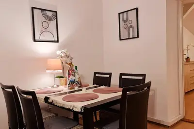 a dining room table with chairs and a table with a lamp at Przestronny pokój w mieszkaniu na Filipa in Kraków