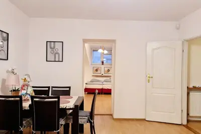 a dining room with a table and chairs and a bedroom at Przestronny pokój w mieszkaniu na Filipa in Kraków