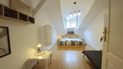a bedroom with a bed and a table with a lamp at Przestronny pokój w mieszkaniu na Filipa in Kraków