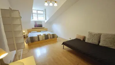 a bedroom with a bed and a couch in a room at Przestronny pokój w mieszkaniu na Filipa in Kraków