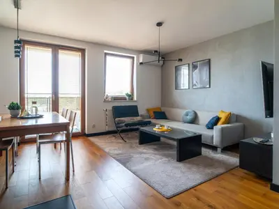 a living room with a couch and a table at Grey Wall Apartment Kraków in Kraków