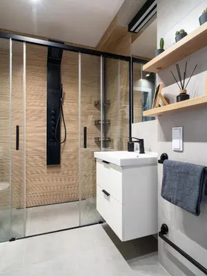 a bathroom with a shower and a white sink at Grey Wall Apartment Kraków in Kraków
