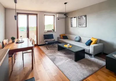 a living room with a couch and a table at Grey Wall Apartment Kraków in Kraków
