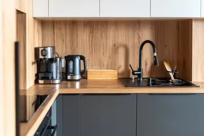 a kitchen with a sink and a coffee maker on a counter at Grey Wall Apartment Kraków in Kraków