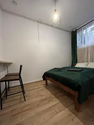 a bedroom with a bed and a desk and a chair at TomTom Hostel in Kraków