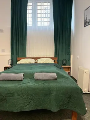 a large green bed with two pillows on it at TomTom Hostel in Kraków