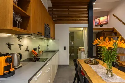 a kitchen with wooden cabinets and a table with yellow flowers at Vintage Bracka 6 Apartment in Kraków