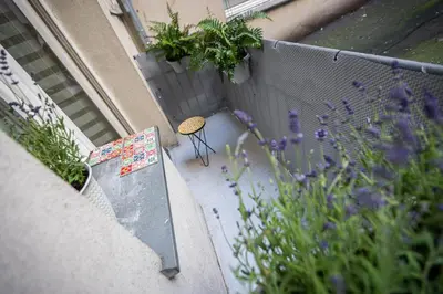 a patio with a bench and purple flowers and a fence at Vintage Bracka 6 Apartment in Kraków