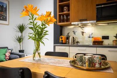 a table with a vase with yellow flowers on it at Vintage Bracka 6 Apartment in Kraków