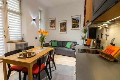 a kitchen and a living room with a table at Vintage Bracka 6 Apartment in Kraków