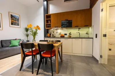 a kitchen and living room with a table and chairs at Vintage Bracka 6 Apartment in Kraków