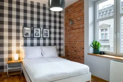 a bedroom with a bed and a brick wall at Discover Krakow Apartments - Lubicz St - Loft - Next to Main Station, AC in Kraków