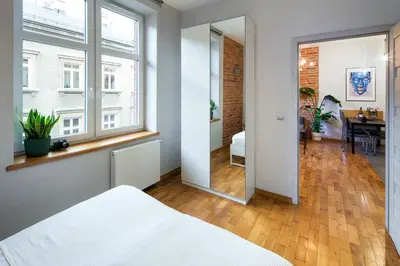 a bedroom with a white bed and a mirror at Discover Krakow Apartments - Lubicz St - Loft - Next to Main Station, AC in Kraków