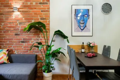 a dining room with a table and a brick wall at Discover Krakow Apartments - Lubicz St - Loft - Next to Main Station, AC in Kraków