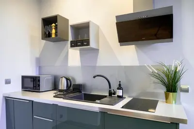 a kitchen with a sink and a microwave at Discover Krakow Apartments - Lubicz St - Loft - Next to Main Station, AC in Kraków