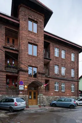 a brick building with cars parked in front of it at Discover Krakow Apartments - Lubicz St - Loft - Next to Main Station, AC in Kraków