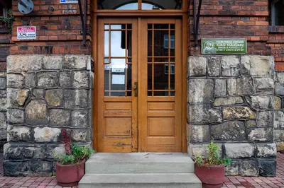 a wooden door of a building with two potted plants at Discover Krakow Apartments - Lubicz St - Loft - Next to Main Station, AC in Kraków