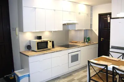 a kitchen with white cabinets and a microwave on the counter at Apartment San Sebastian, City Center in Kraków