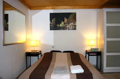 a bedroom with a bed and two lamps on two tables at Apartment San Sebastian, City Center in Kraków
