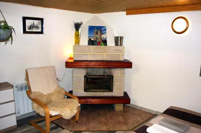 a living room with a fireplace and a chair at Apartment San Sebastian, City Center in Kraków