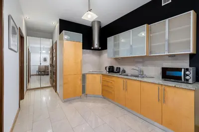 a kitchen with wooden cabinets and a sink at Wawel Apartments - Old Town in Kraków