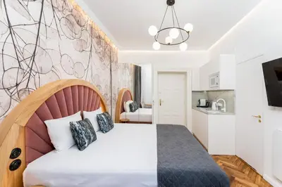 a bedroom with a bed and a kitchen at Wawel Apartments - Old Town in Kraków