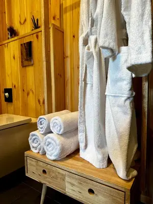 a pile of towels on a wooden table in a bathroom at Brown Deer - z Sauną na Tarasie, Jacuzzi i Widokiem na Góry - by Deer Hills Luxury Apartments in Kocoń