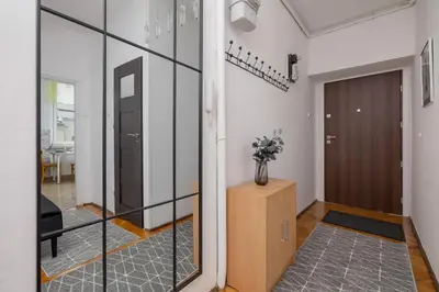 a hallway with a sliding glass door and a table at Rodzinny Apartament z dwiema sypialniami niedaleko centrum Krakowa by Noclegi Renters in Kraków