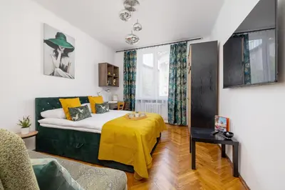 a bedroom with a bed with a yellow blanket on it at Rodzinny Apartament z dwiema sypialniami niedaleko centrum Krakowa by Noclegi Renters in Kraków