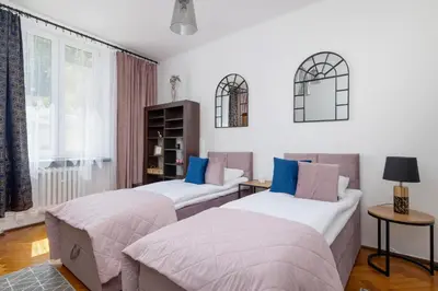 a bedroom with two beds and a window at Rodzinny Apartament z dwiema sypialniami niedaleko centrum Krakowa by Noclegi Renters in Kraków