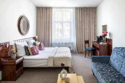 a hotel room with a bed and a couch at Old Time Aparthotel in Kraków