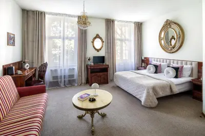 a bedroom with a bed and a table and a couch at Old Time Aparthotel in Kraków