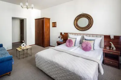 a bedroom with a large bed and a blue couch at Old Time Aparthotel in Kraków