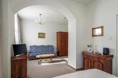 a living room with a couch and a tv at Old Time Aparthotel in Kraków