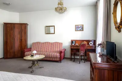 a living room with a couch and a chair at Old Time Aparthotel in Kraków