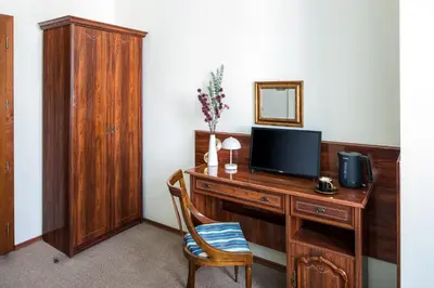 a room with a desk with a television and a chair at Old Time Aparthotel in Kraków