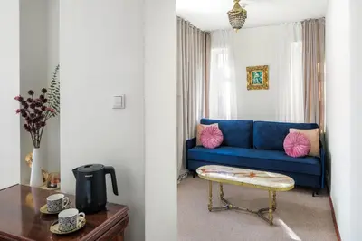 a blue couch in a living room with a table at Old Time Aparthotel in Kraków