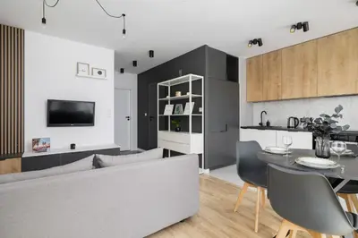 a living room with a couch and a table at Elegant Apartment in Cracow with Balcony, Parking and Desk by Noclegi Renters in Kraków