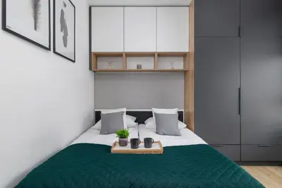 a bedroom with a bed with a green blanket at Elegant Apartment in Cracow with Balcony, Parking and Desk by Noclegi Renters in Kraków