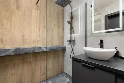a bathroom with a sink and a glass shower at Elegant Apartment in Cracow with Balcony, Parking and Desk by Noclegi Renters in Kraków