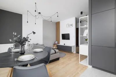 a dining room and living room with a table and a couch at Elegant Apartment in Cracow with Balcony, Parking and Desk by Noclegi Renters in Kraków