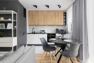 a kitchen and living room with a table and chairs at Elegant Apartment in Cracow with Balcony, Parking and Desk by Noclegi Renters in Kraków