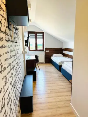 a bedroom with two beds and a writing wall at Agawa restauracja&Hotel in Dębno